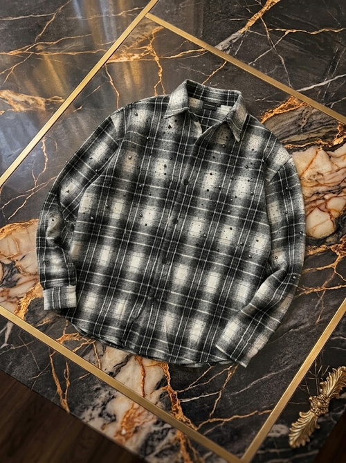 Camicia grigia e nera a quadri con applicazioni, fotografia reale del capo disposto in piano