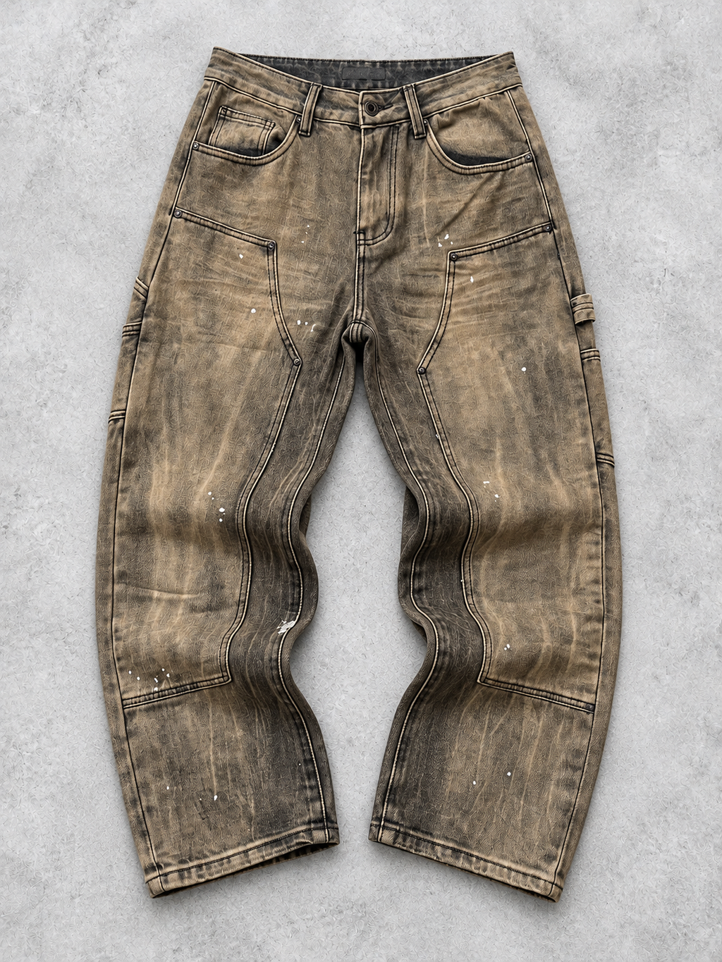 Jeans marrone con schizzi chiari a contrasto, vista frontale in piano su fondo grigio