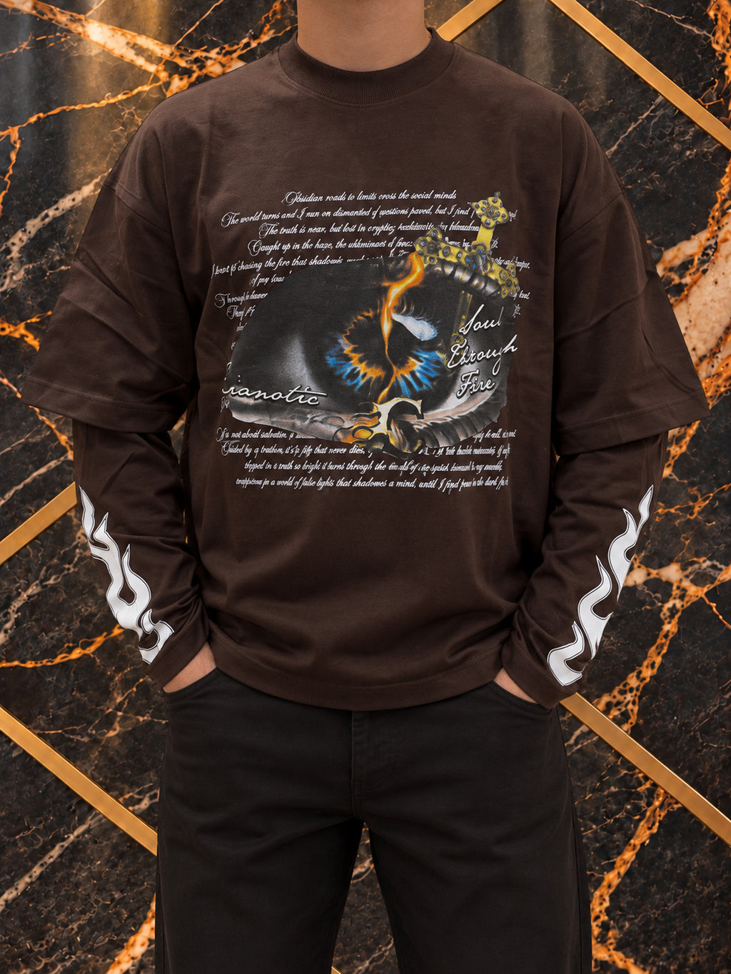 Maglia marrone Cianotic Occhio, indossato, inquadratura senza volto su marmo nero e oro — immagine rielaborata