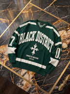 Maglione verde con scollo a V, scritta Black District e dettagli avorio, fotografia reale del capo