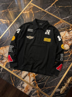 Polo nera a maniche lunghe con patch colorate, fotografia reale del capo